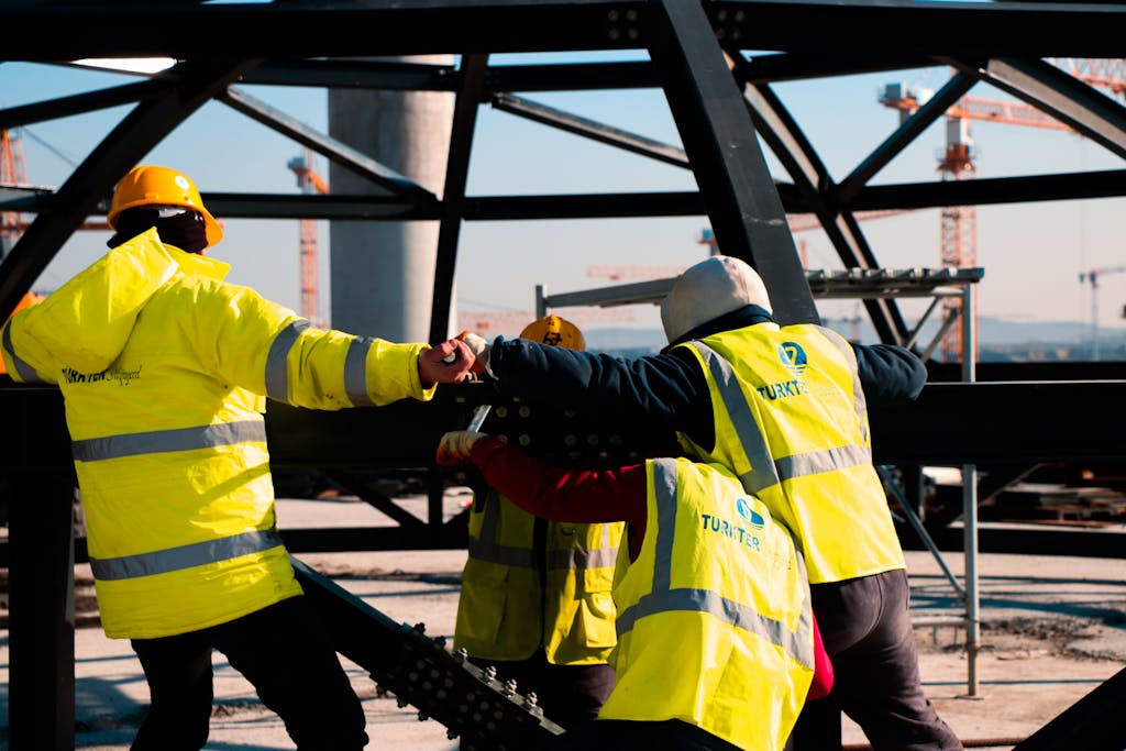 Construction team in Türkiye working on steel framework, showcasing safety and teamwork.